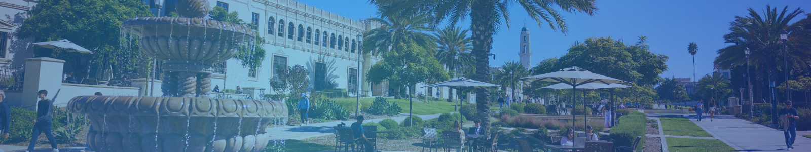 Students walk around the University of San Diego campus in the sunshine with blue sky